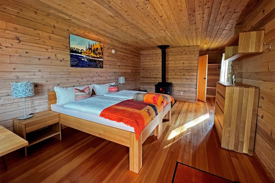 Wooden bedroom with fireplace in Yukon fishing lodge