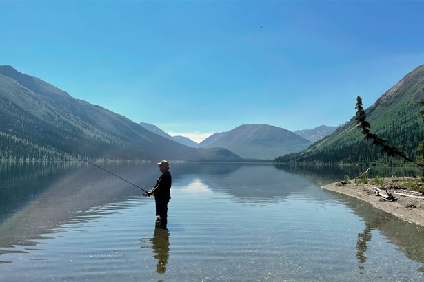 Man fishing in Tincup lake by mountains