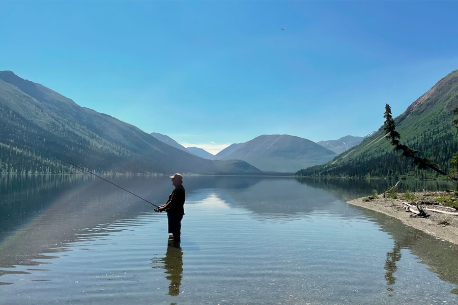 Man fishing in Tincup lake by mountains
