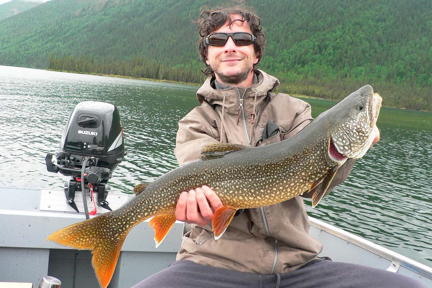 Man with huge fish in boat, Canada