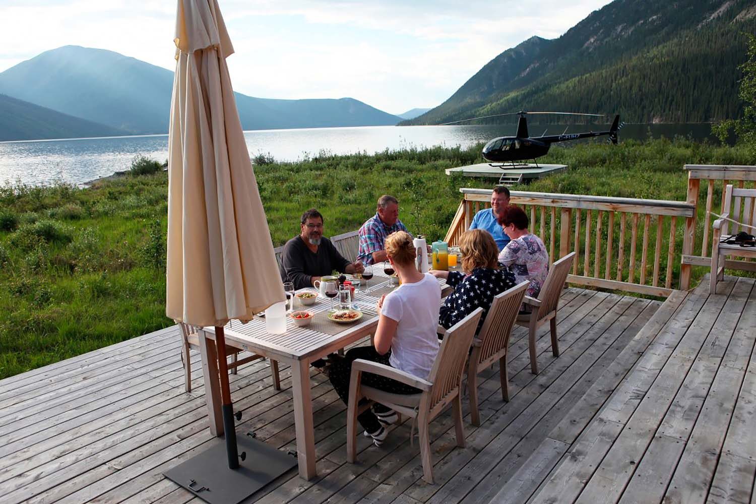 Group of people having dinner in terrace by lake