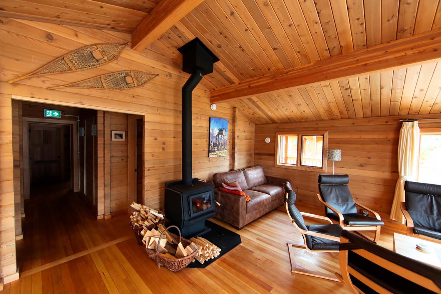 Lounge room with fireplace in wooden lodge, Yukon