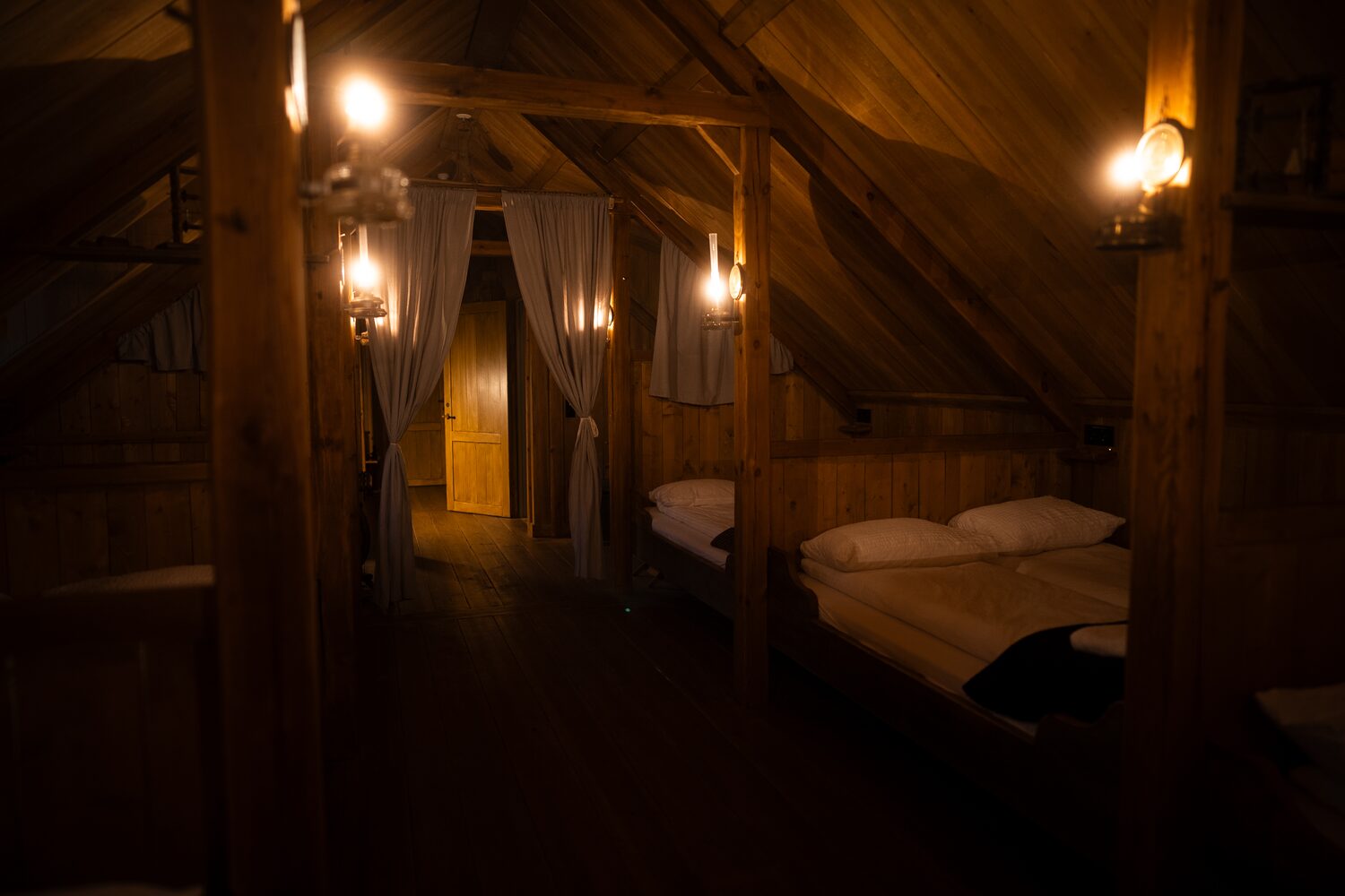 Double bed with white sheets in dormitory room at wilderness center hotel.