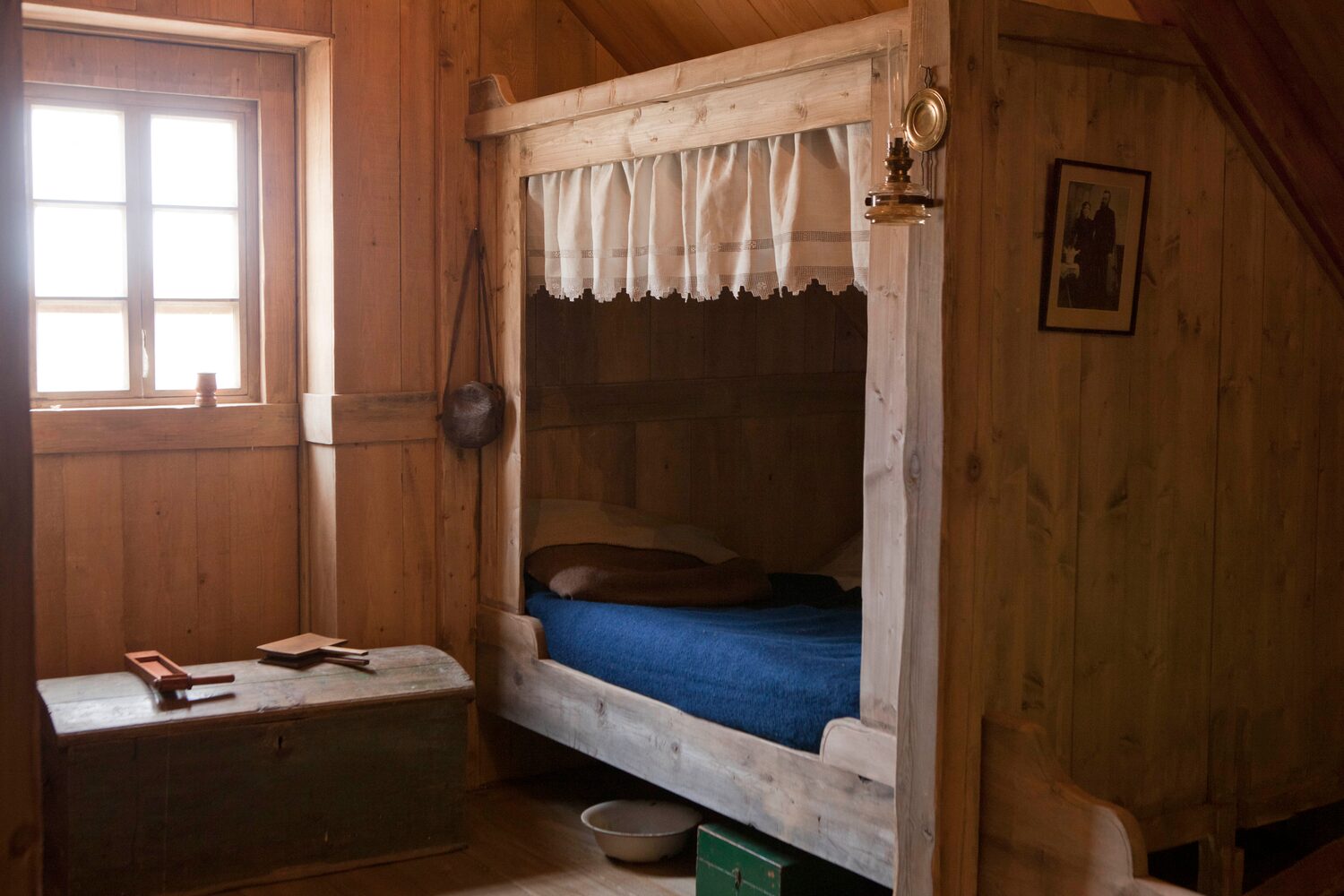 Bed closet with blue sheets and curtain in wilderness hotel Iceland.