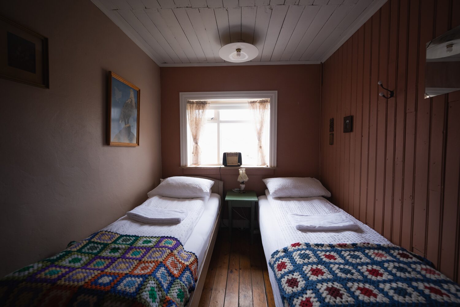 Two single beds with farmhouse style sheets and decor in room at wilderness center hotel.