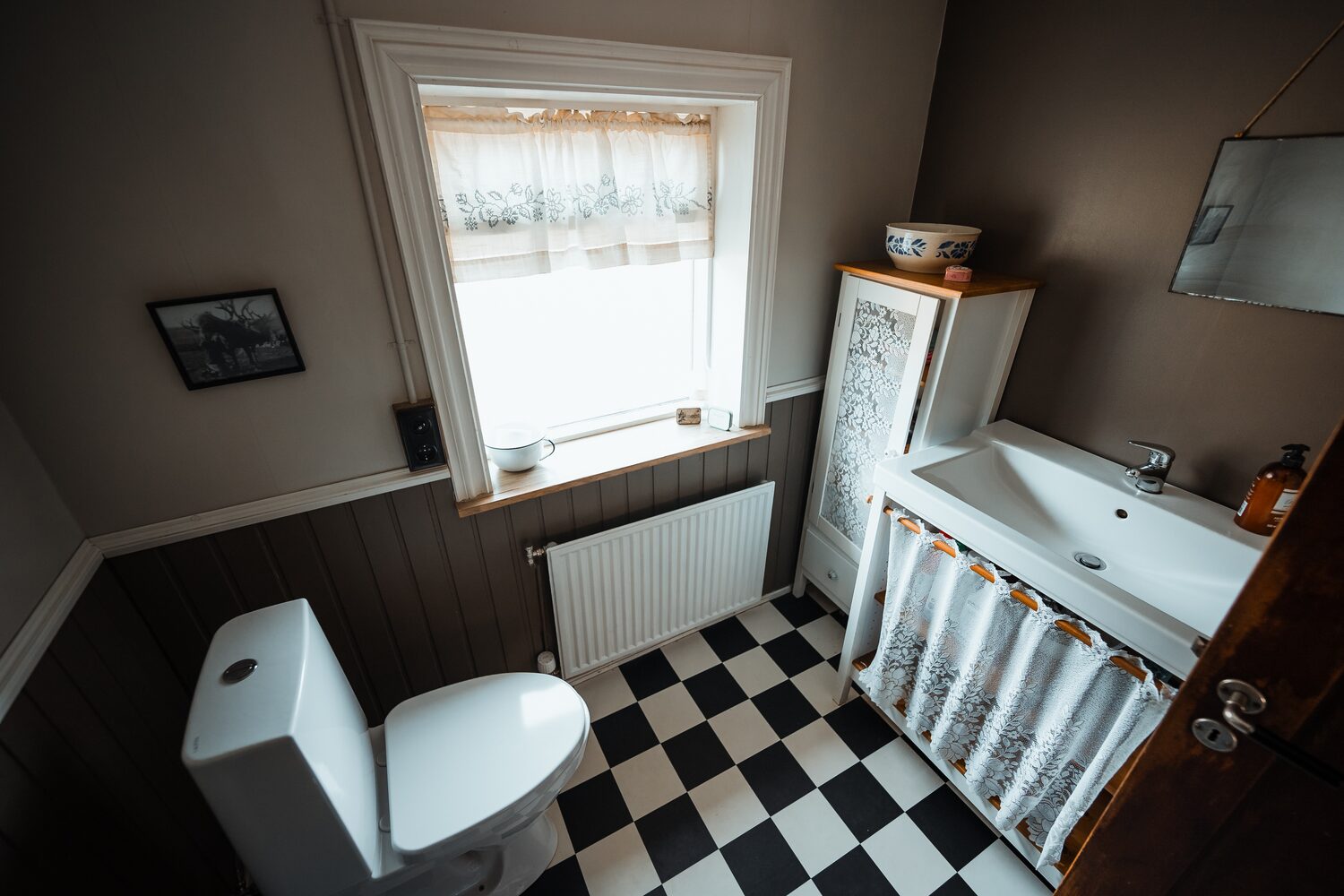 Shared bathroom with black and white square tiled floor at wilderness center hotel.