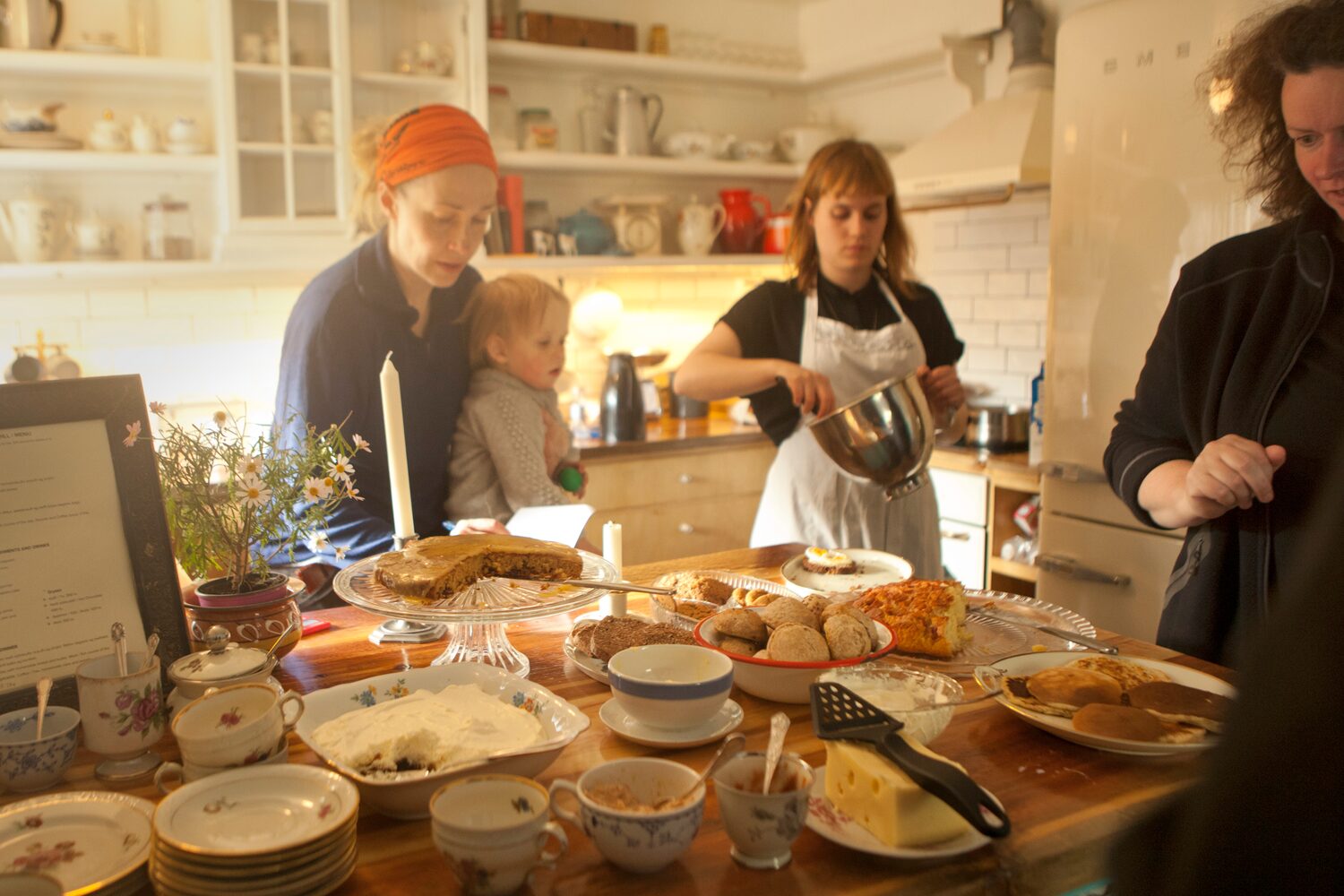 Two ladies in farmhouse style kitchen at wilderness center with spread of food being prepared.