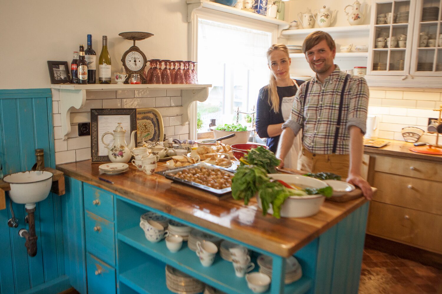 Man and woman standing in farmhouse style kitchen preparing dinner for wilderness center hotel.