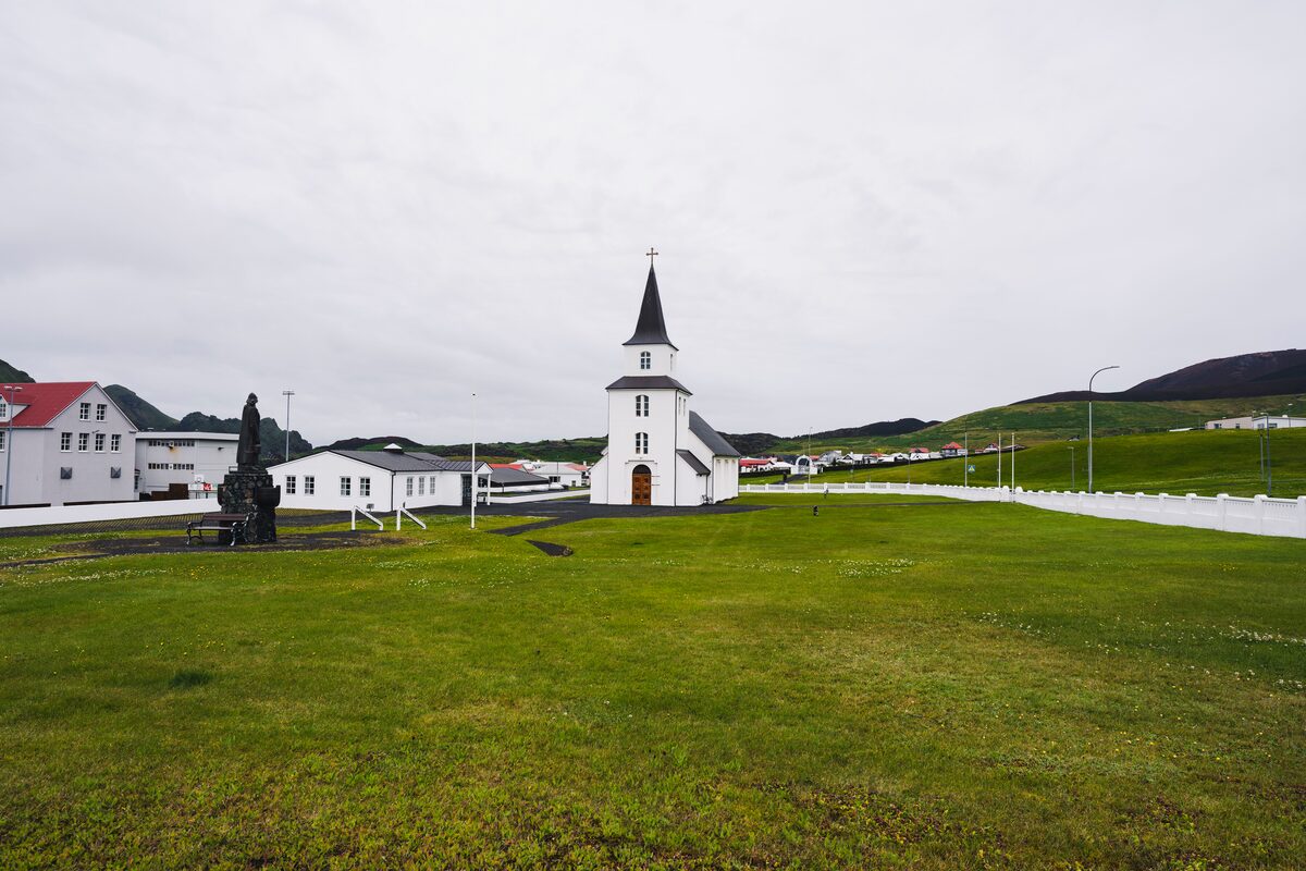 White church by town in Vestmannaeyjar islands