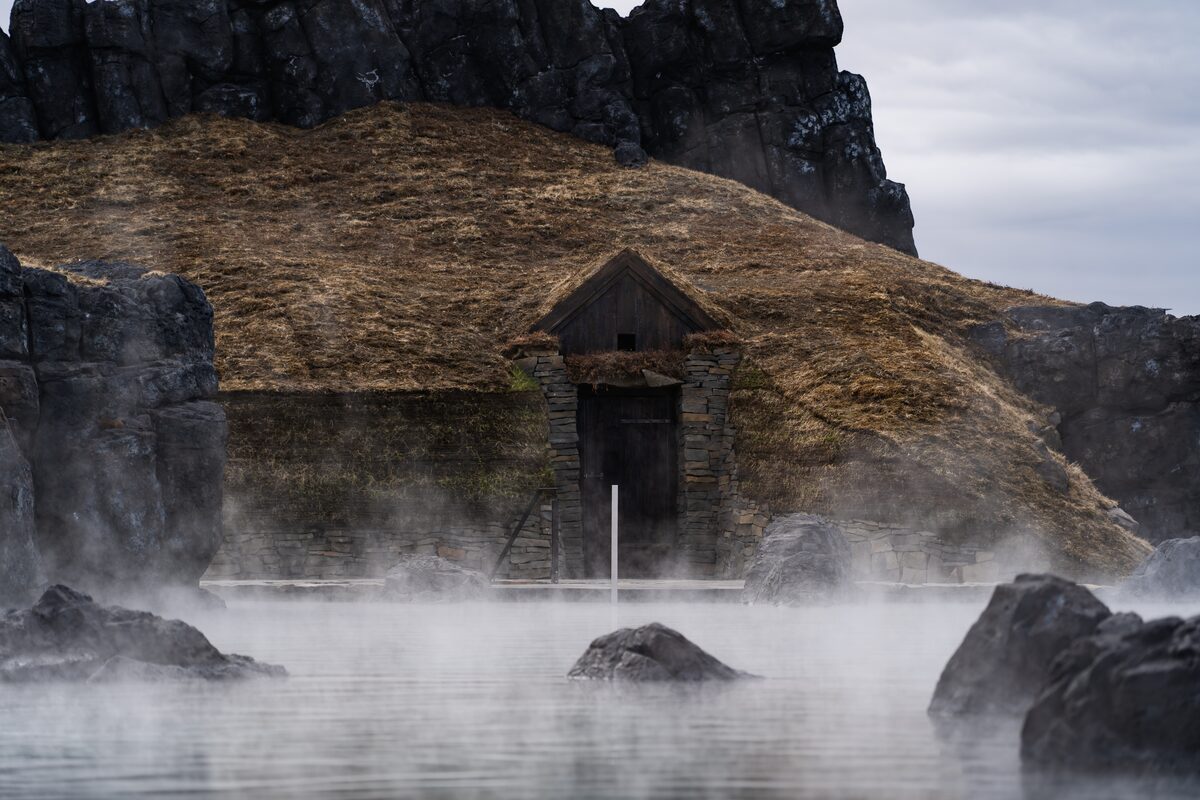 Turfed roof hut by steamy hot lagoon