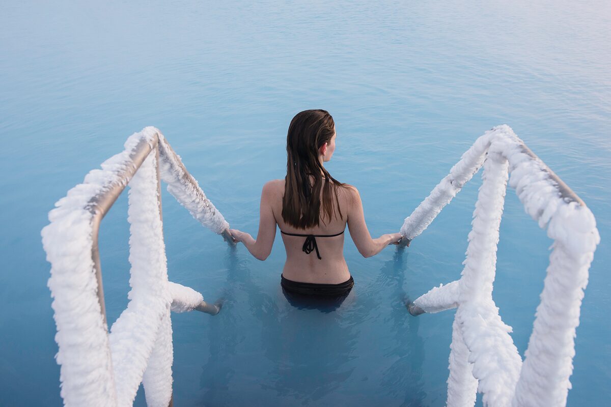 Woman getting into hot blue waters lagoon