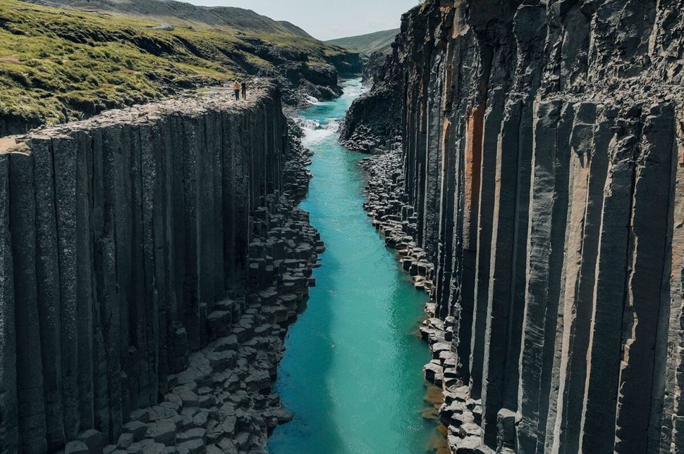Studlagil canyon of basalt columns by blue river
