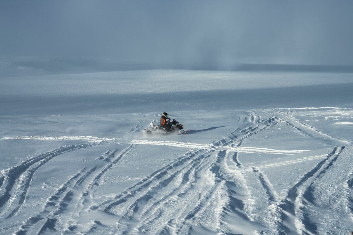 Snowmobiler driving on Langjokull glacier