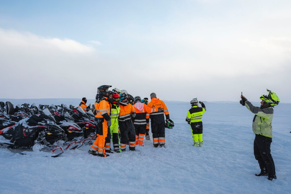 Snowmobilers taking group photo on glacier