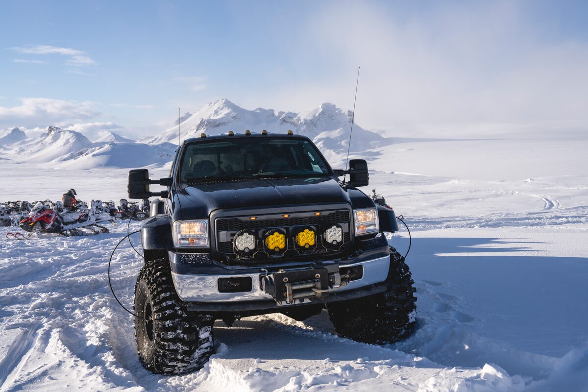 Black super jeep from snowmobiling tour driving through Langjokull
