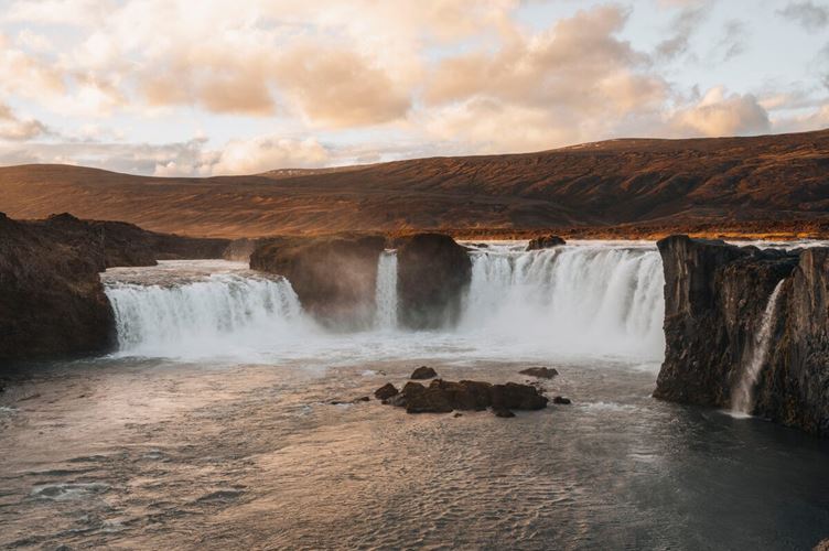 Sunset View Godafoss Trio of waterfalls cascading into river by bed of autumn covered land