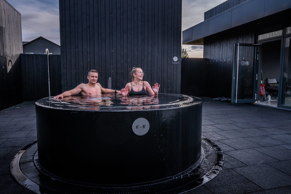 Young attractive couple relaxing and enjoying geothermal hot tub 
