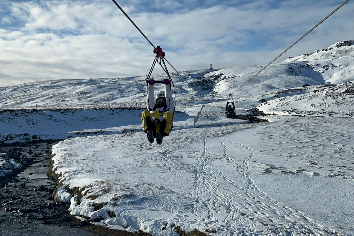 Beautiful snowy mountain views and tourist on ziplining adventure