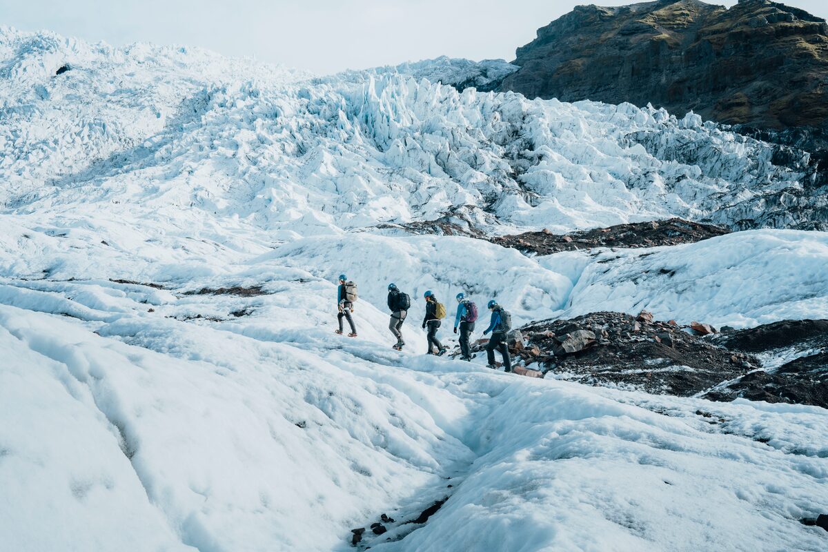 Small group glacier hiking across Vatnajokull glacier landscape in spring.