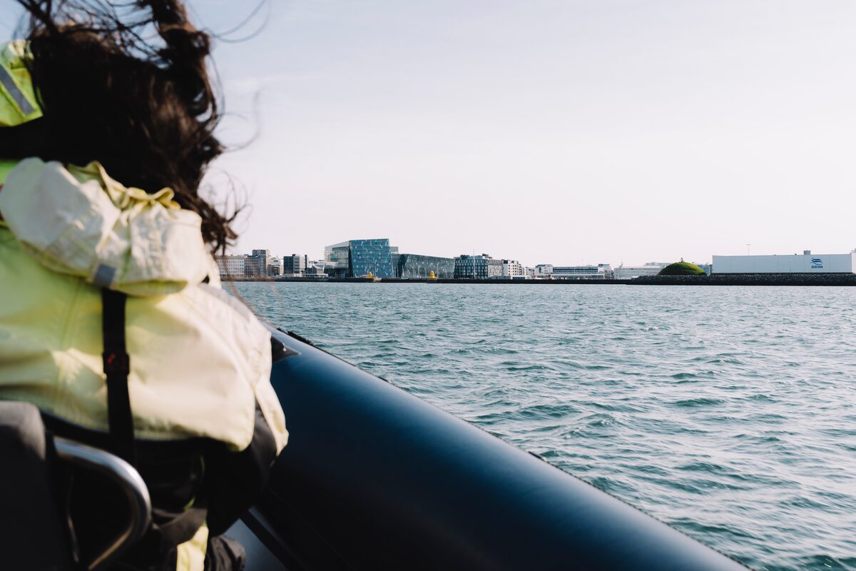 Rib boat driving past Harpa concert music hall in Reykjavik.