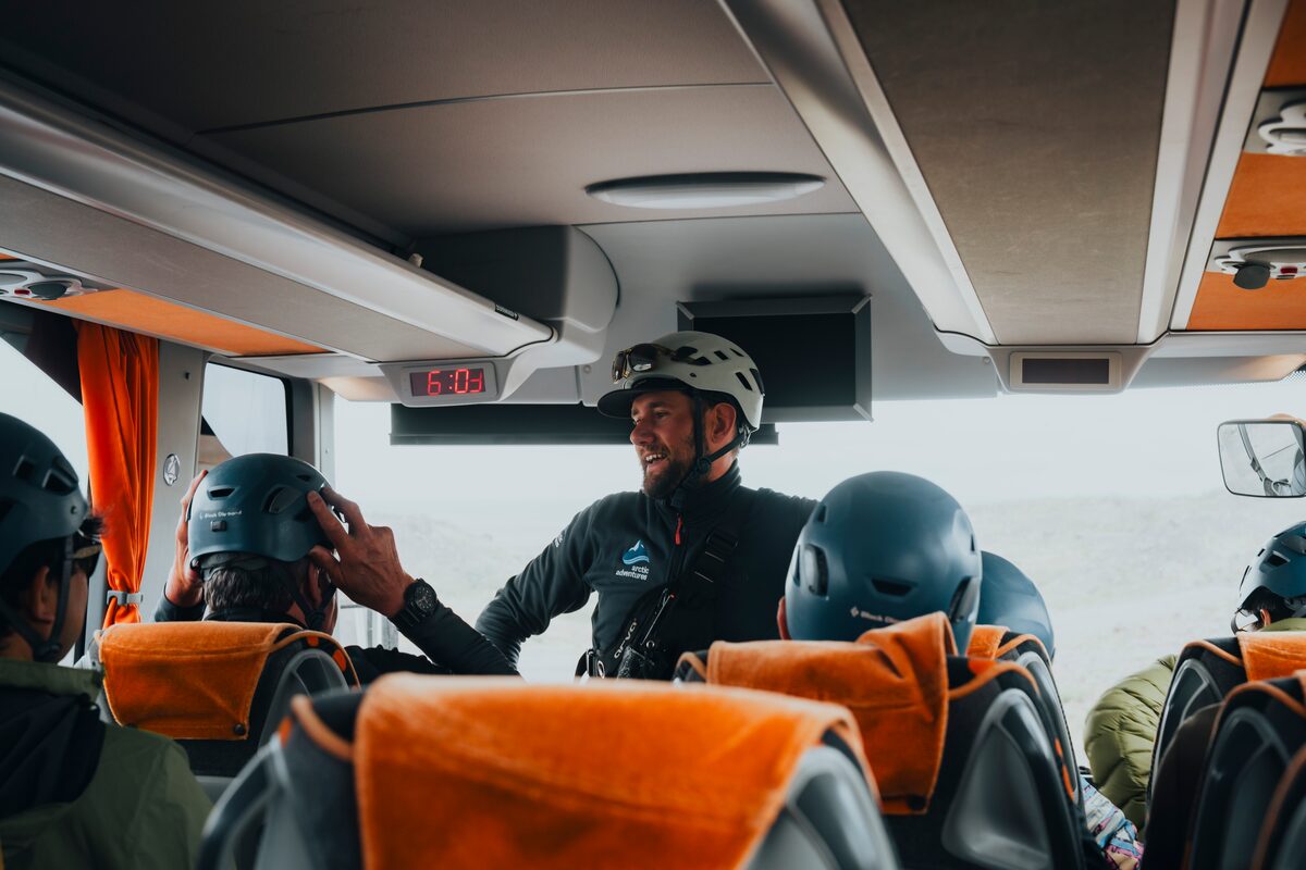 Tour guide wearing safety gear at front of tour bus close to Skaftafell.