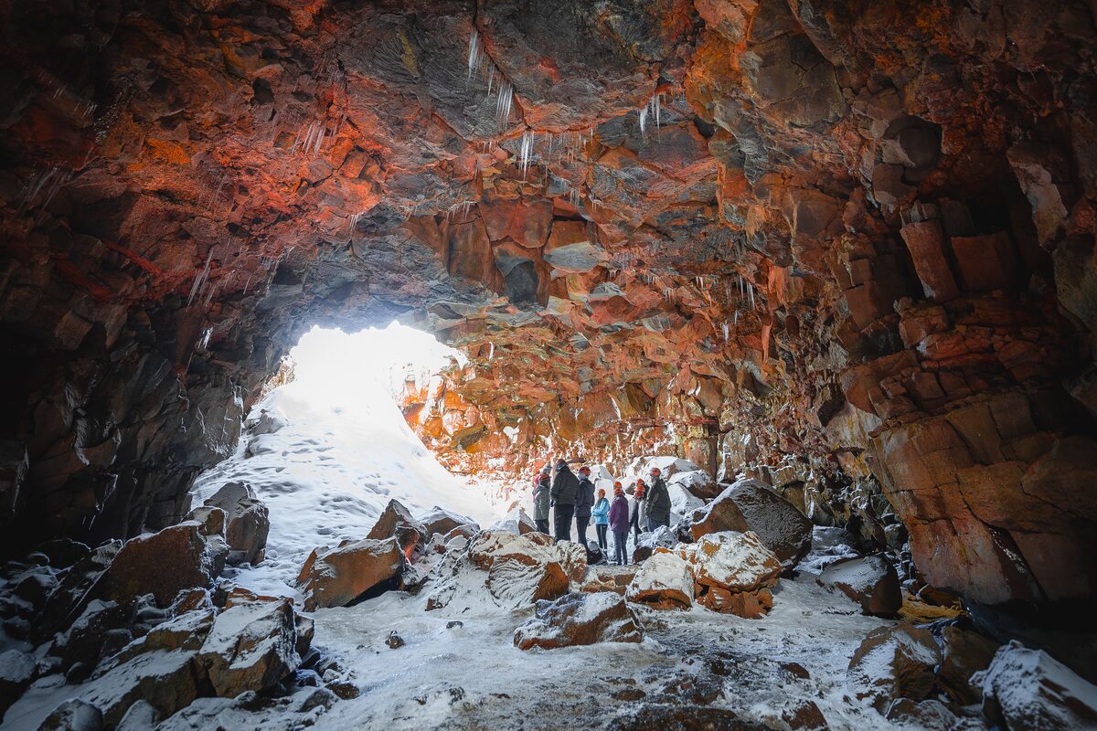Tourists Standing In A Snowy Lava Tunnel
