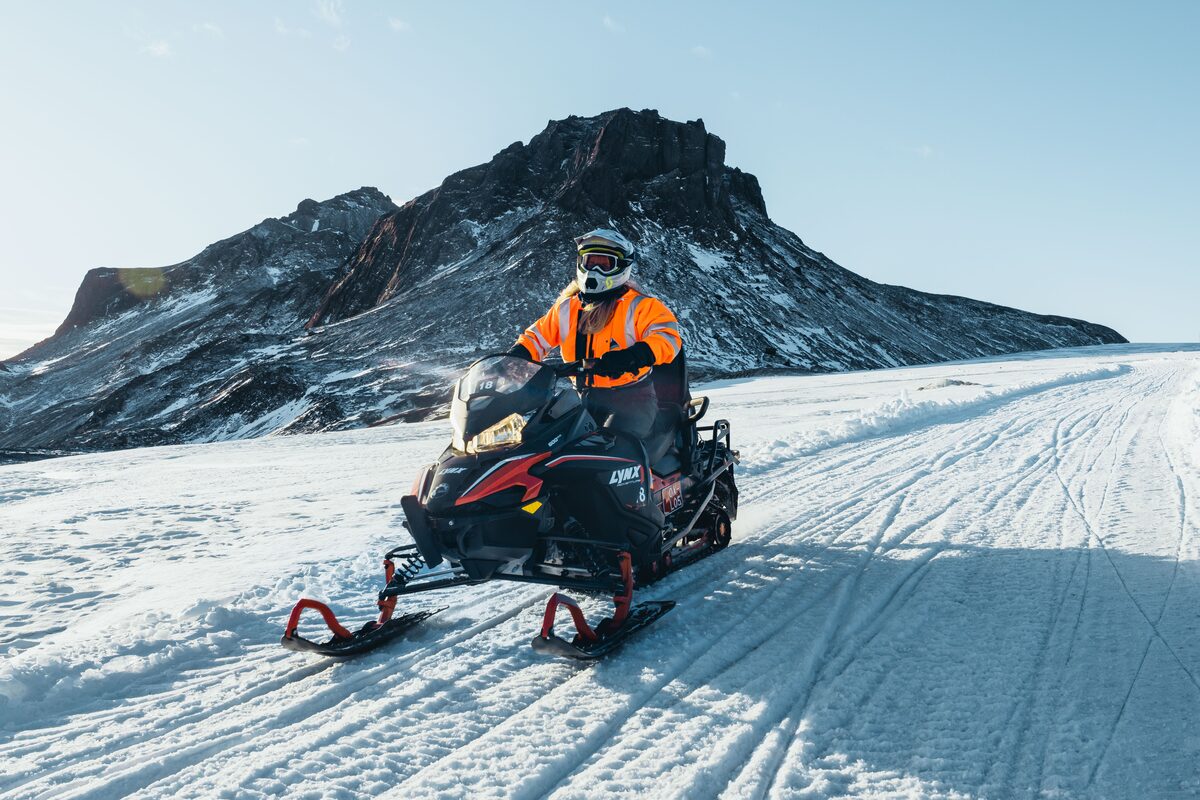 Driver On A Snowbile On Langjokull Glacier In Front Of A Hill
