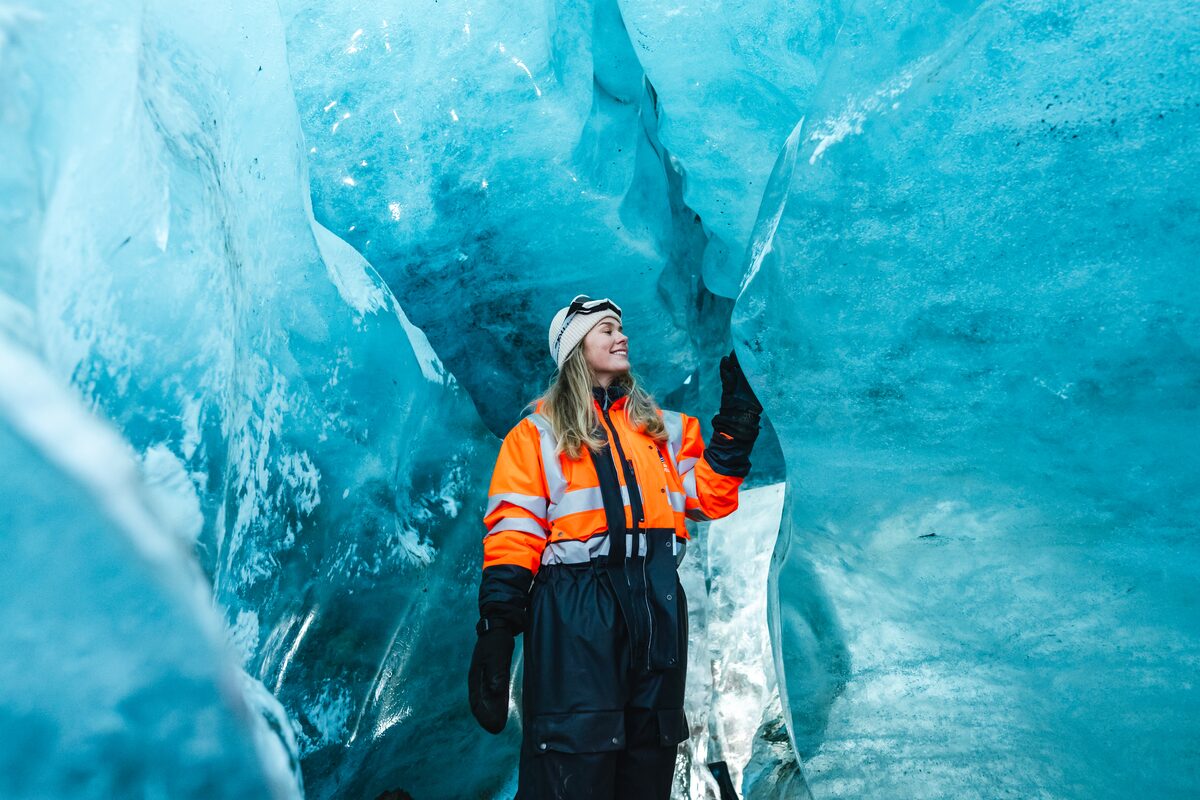 Woman Touching Ice Cave Walls In Iceland