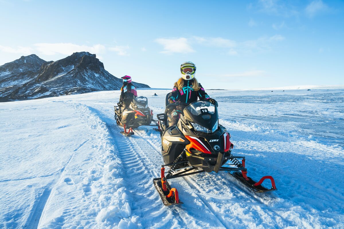 Two Women Drivers On Snowmobiles On A Glacier
