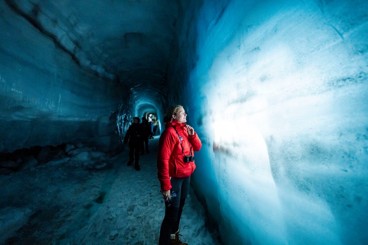 Woman Looking At A Wall Of Ice Tunnel On Langjokull Glacier in iceland