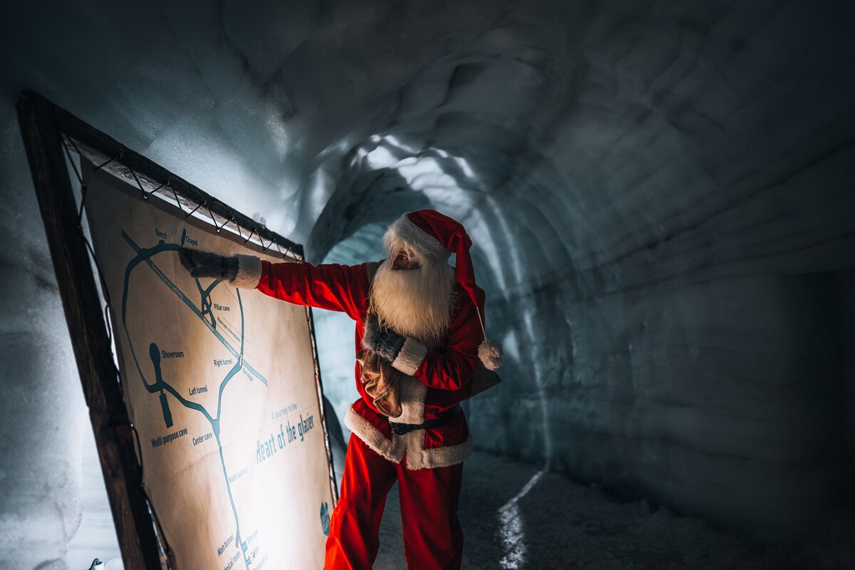 Yule Lad Looking And Pointing To The Map Of Ice Tunnel On Langjokull in iceland
