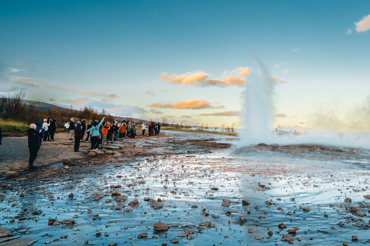 Tourists Looking At Erupting Geysir in iceland