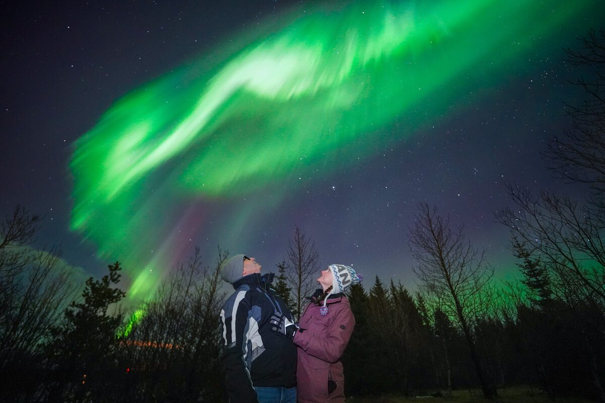 Couple Side Profile Looking Up At Northern Lights in iceland