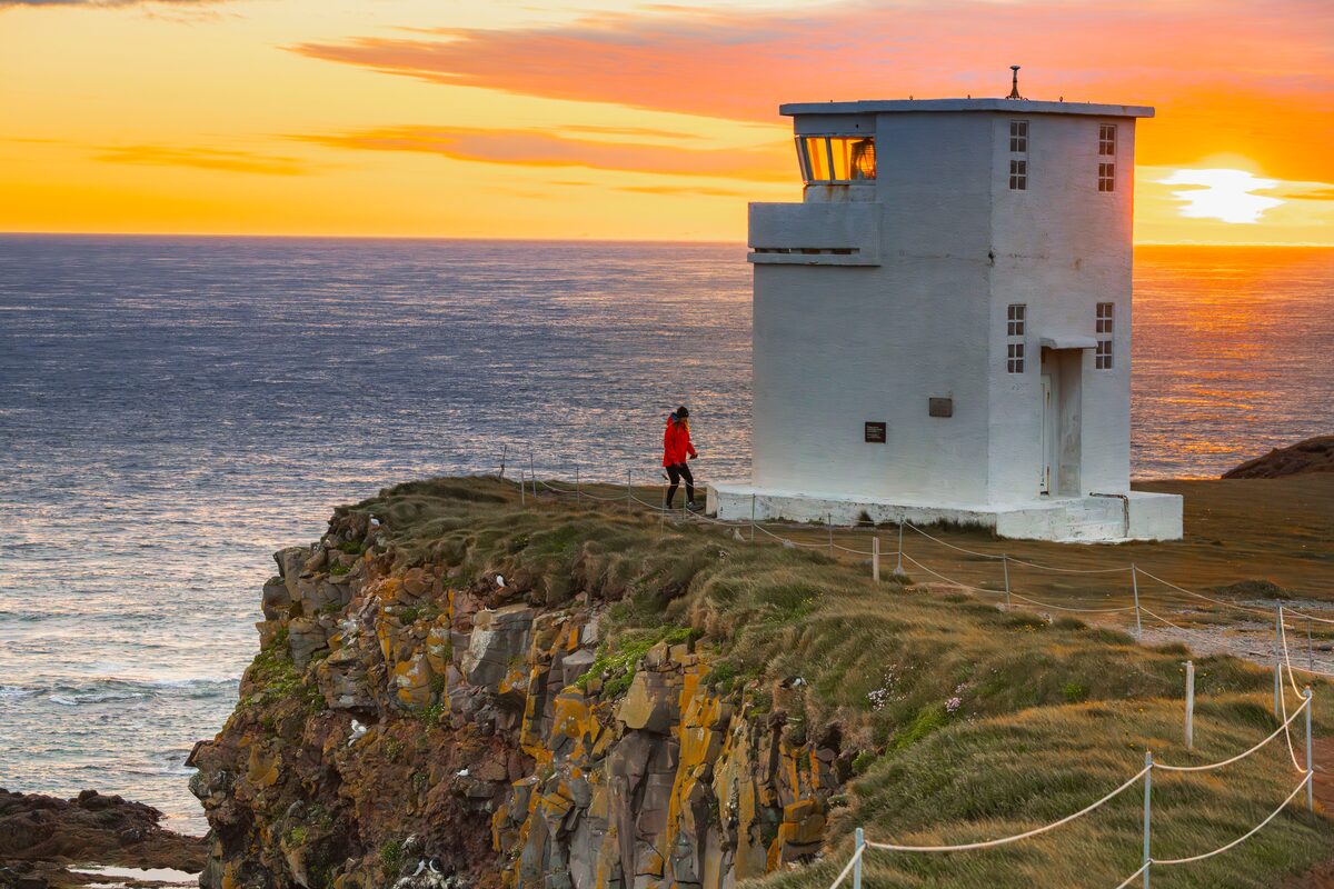 Person Next To A Lighthouse In Westfjords in iceland