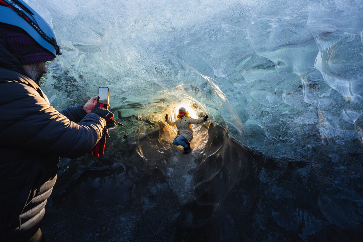 Man Photographing A Woman In An Ice Tunnel At Crystal Ice Cave in iceland
