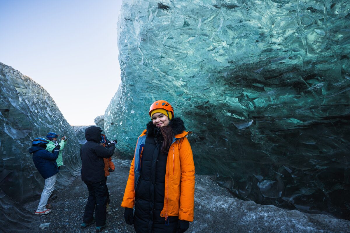 Woman In An Orange Jacket At Crystal Ice Cave in iceland