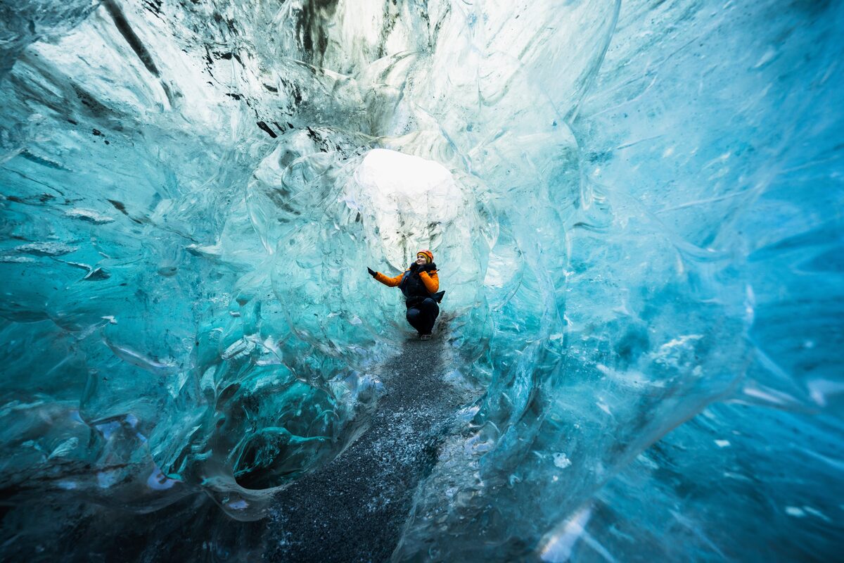 Woman Squating In A Tunnel Of Crystal Ice Cave in iceland