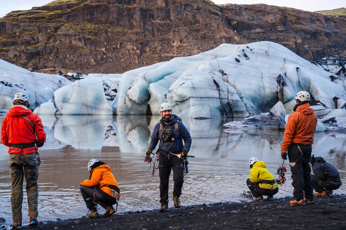 Group Of Tourists Near Water On A Glacier Hike in iceland