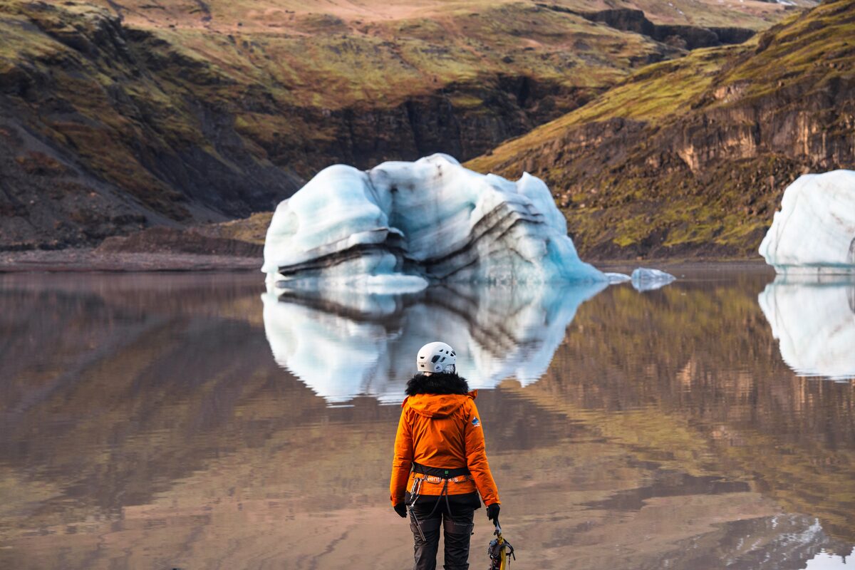 Woman In An Orange Jacket In Front Of Glacier Lagoon in iceland
