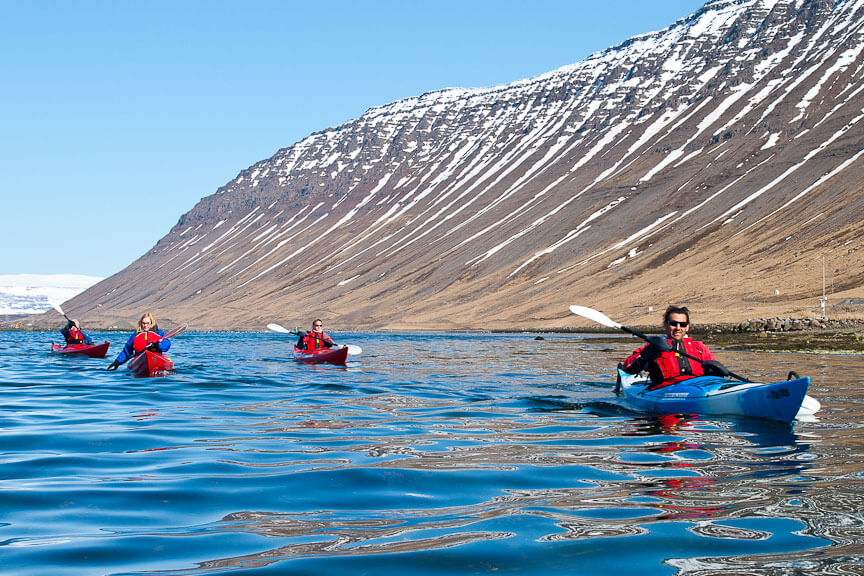 Four Kayakers In Water With A Snowy Mountain In The Background in Iceland