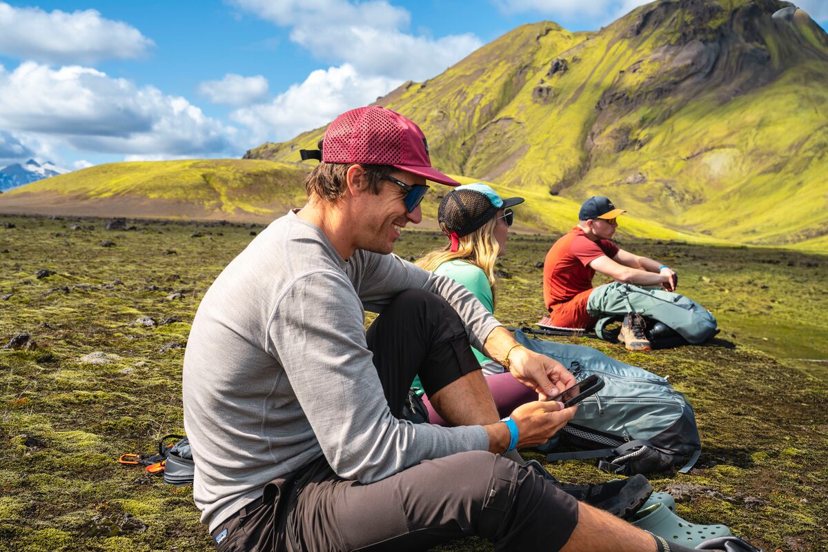 Hikers Having A Break Sitting On The Ground At Landmannalaugar in Iceland