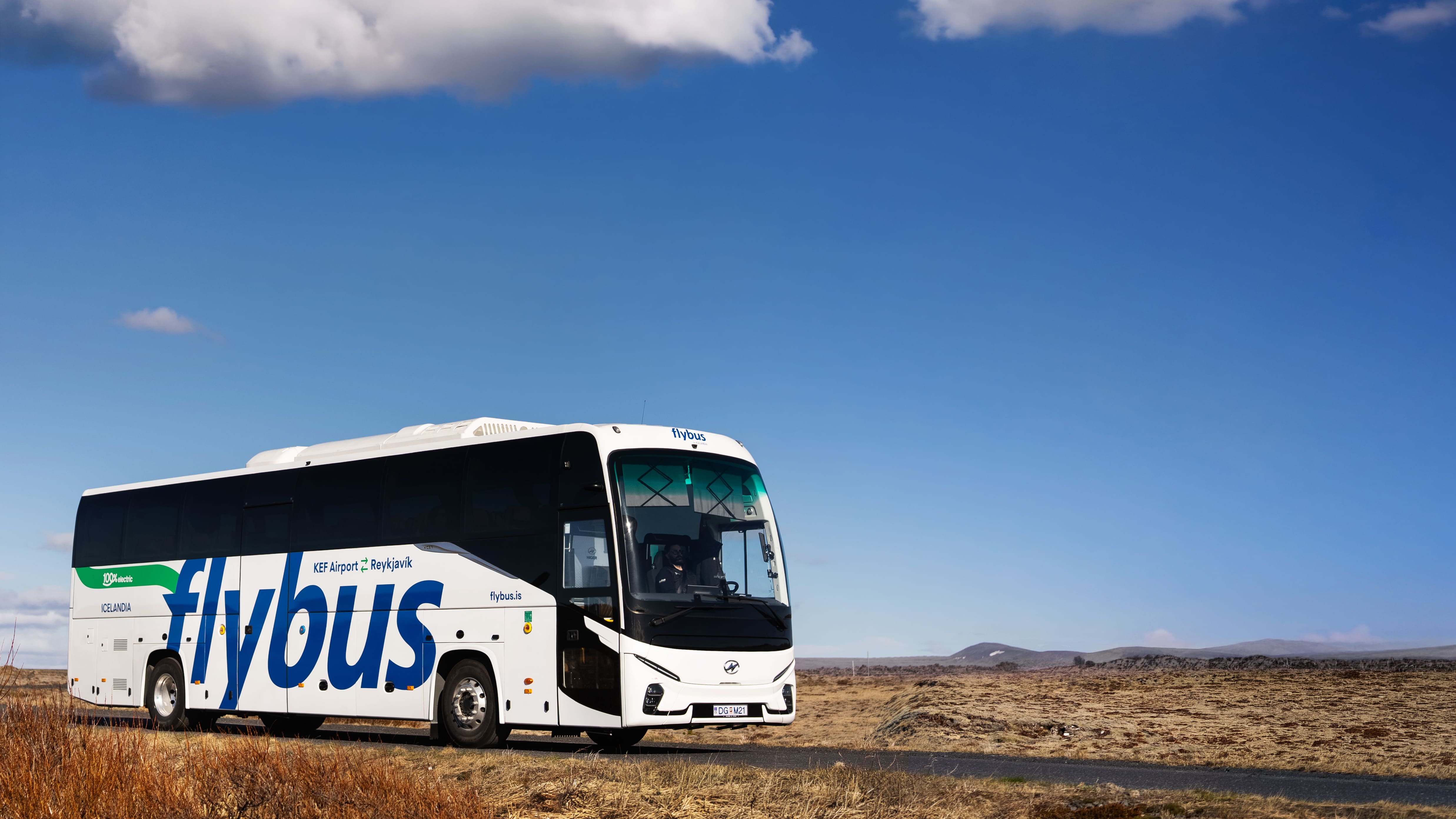 Flybus Bus Standing On The Road Surrounded By Lava Fields in Iceland