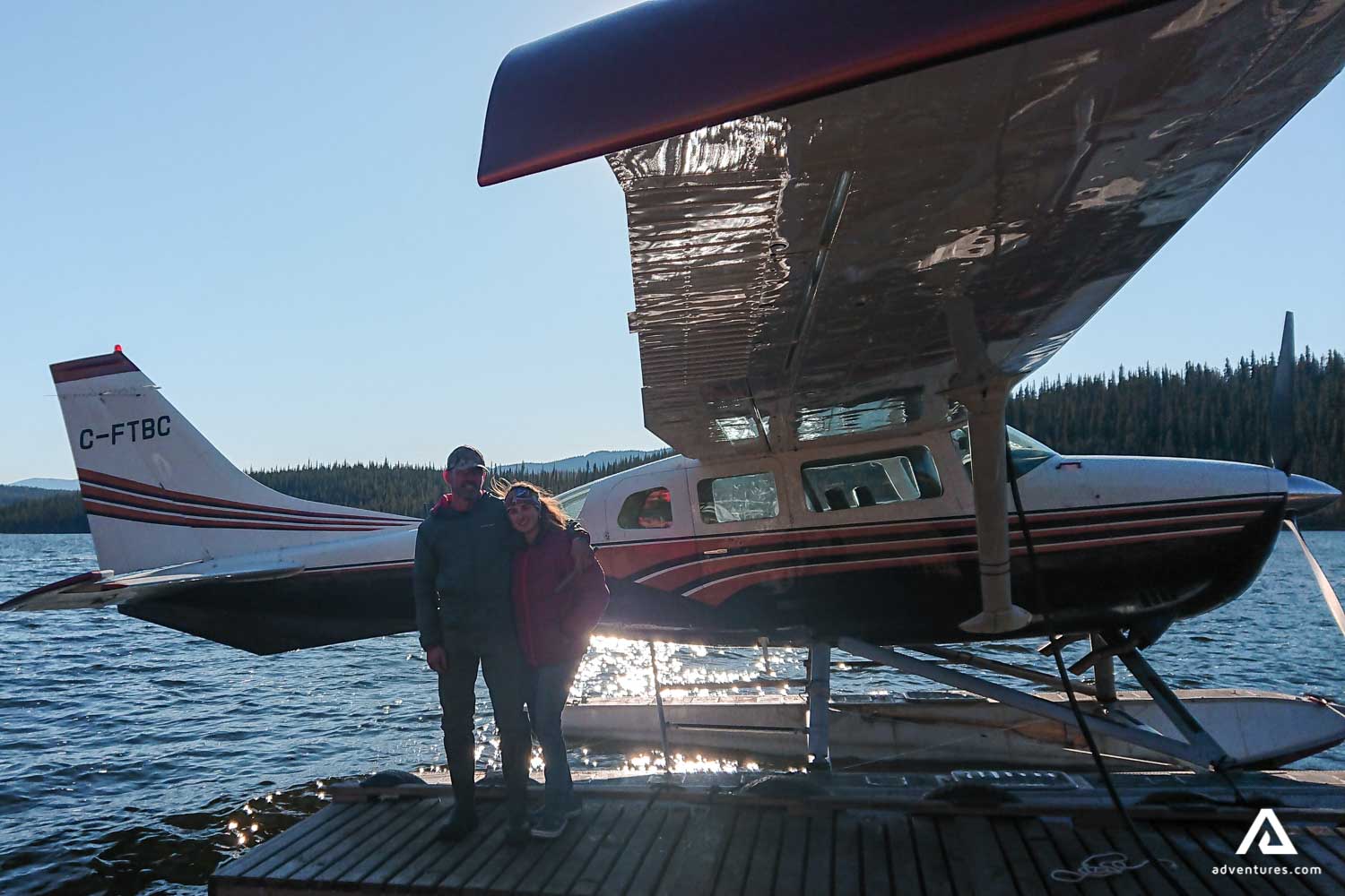 Couple near bushplane on the lake