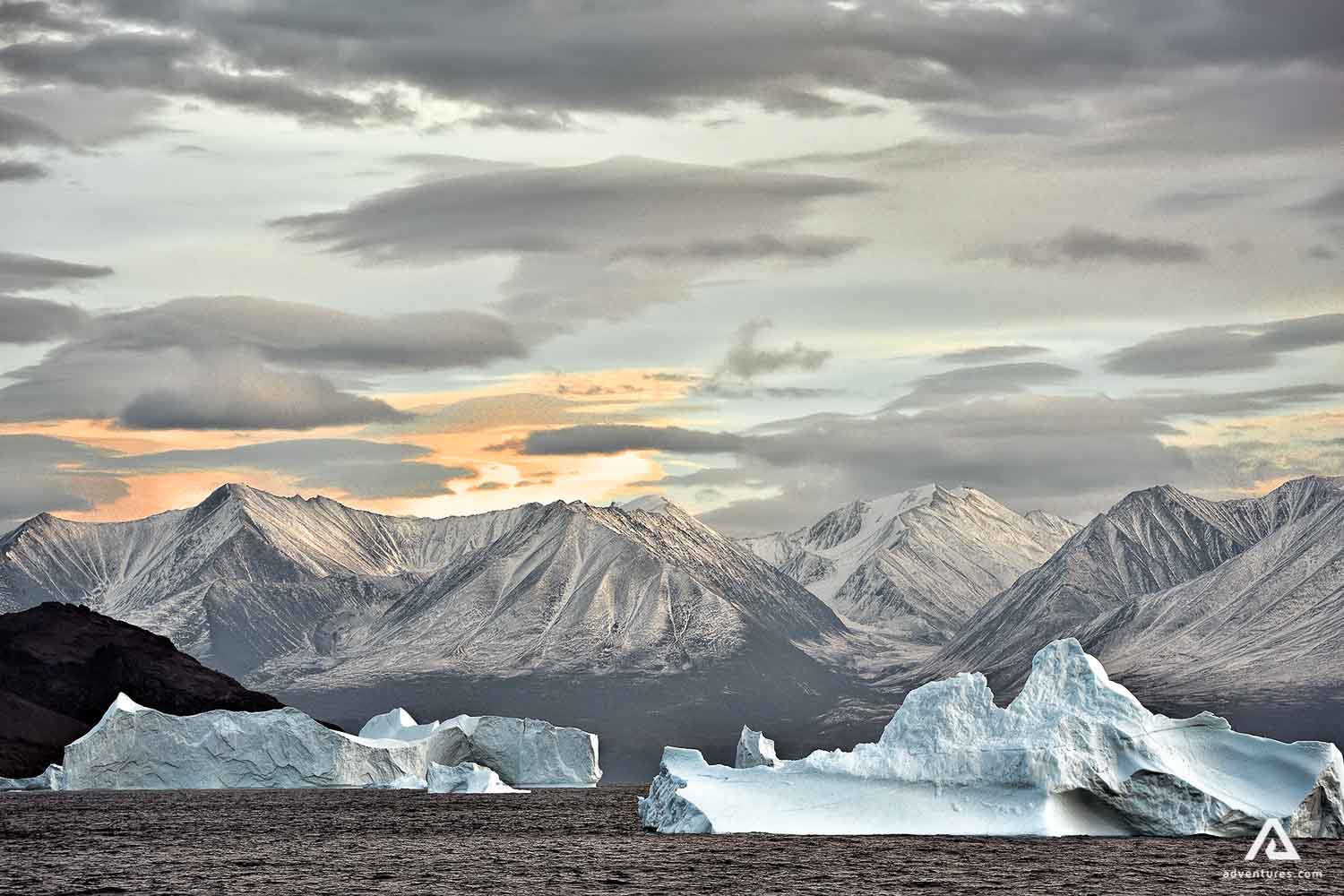 Iceberg with mountain ranges in background