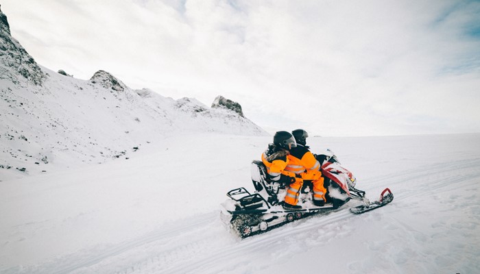 Couple riding snowmobile