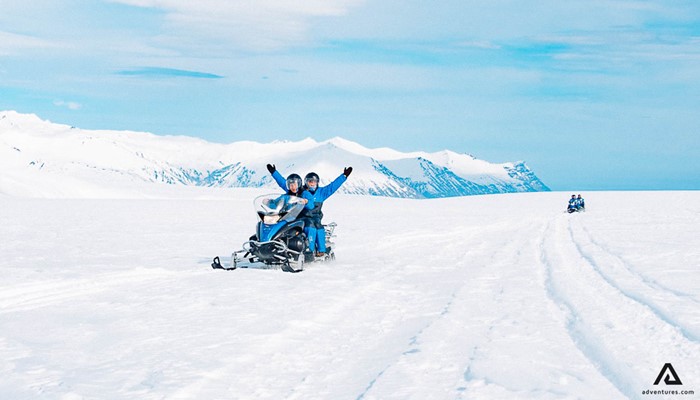 Riding snowmobile with raised hands
