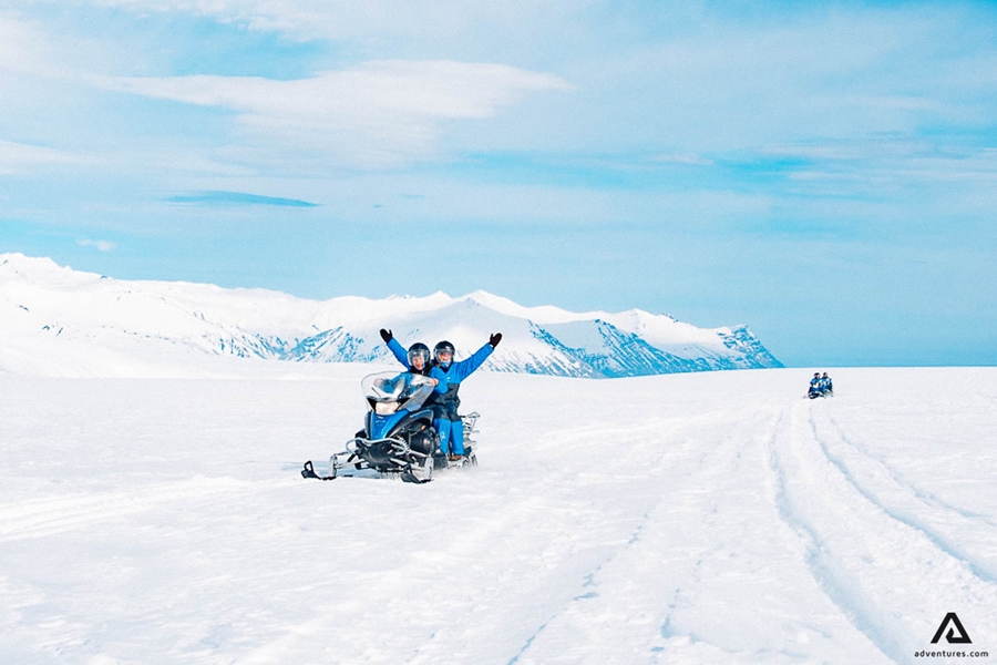 Snowmobiling with raised hands