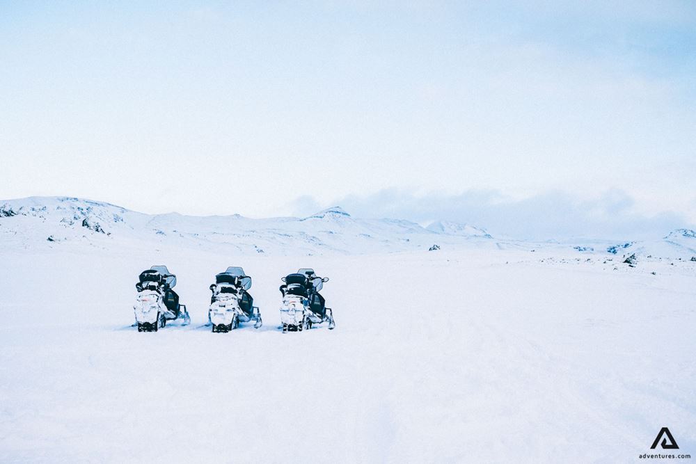 Snowmobiles standing in a row