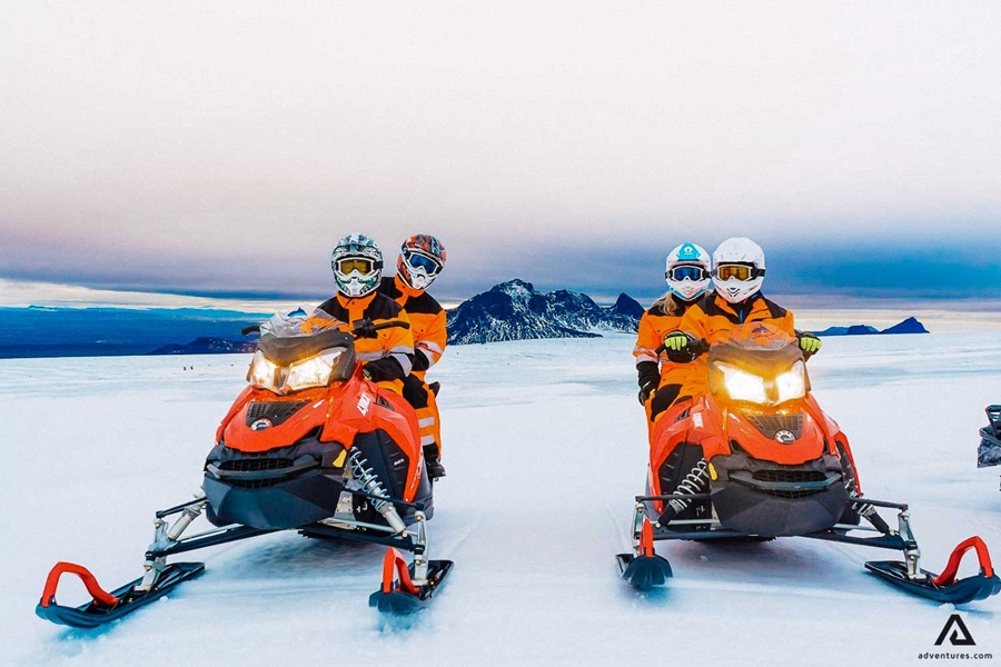 Two people riding snowmobile