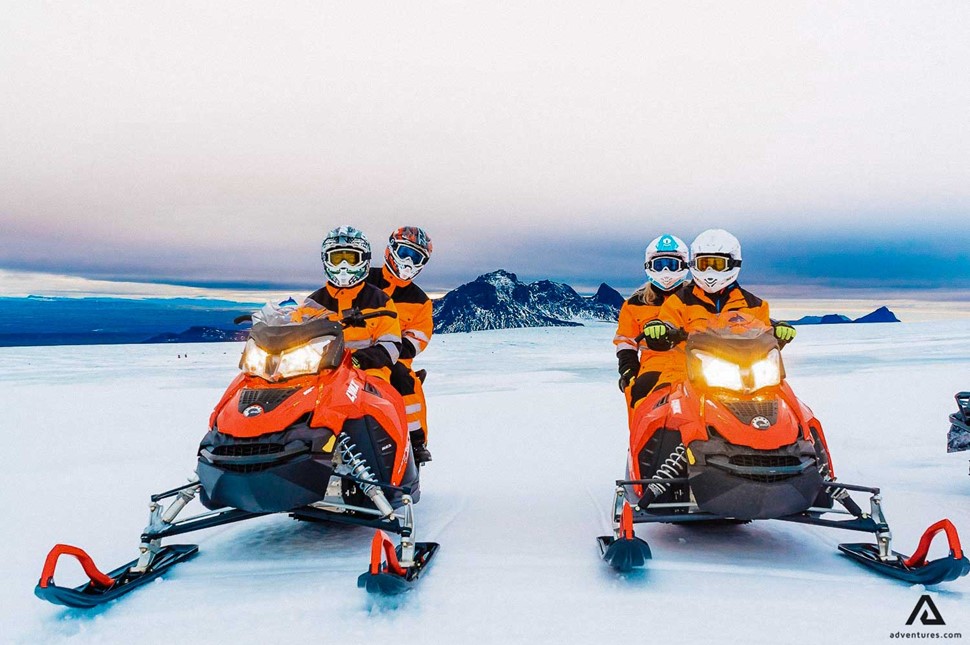 Two people riding snowmobile in Iceland